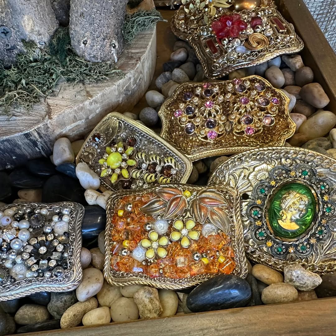 Embellished vintage jewelry pieces displayed on river stones